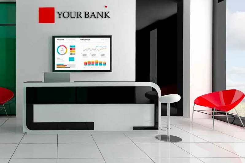 Accueil d’une banque avec un écran affichant des graphiques au mur