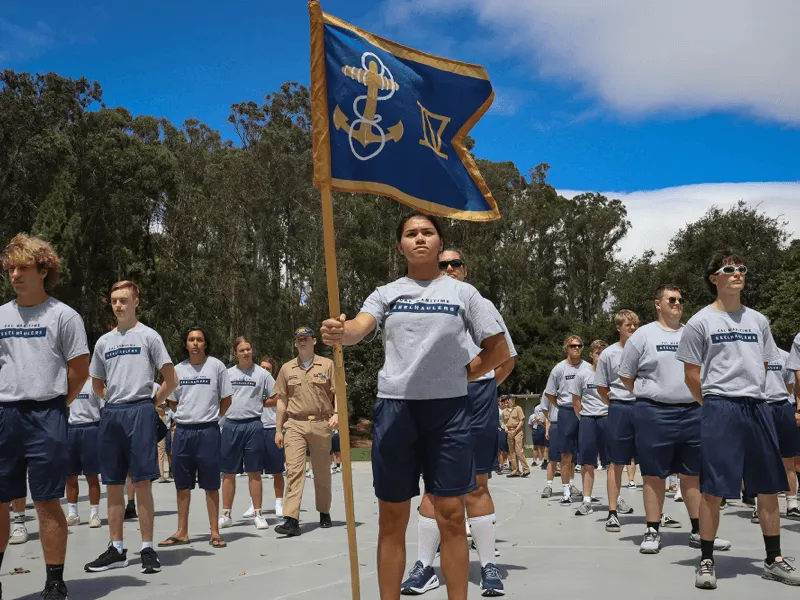 Cadets en uniforme défilant avec un drapeau