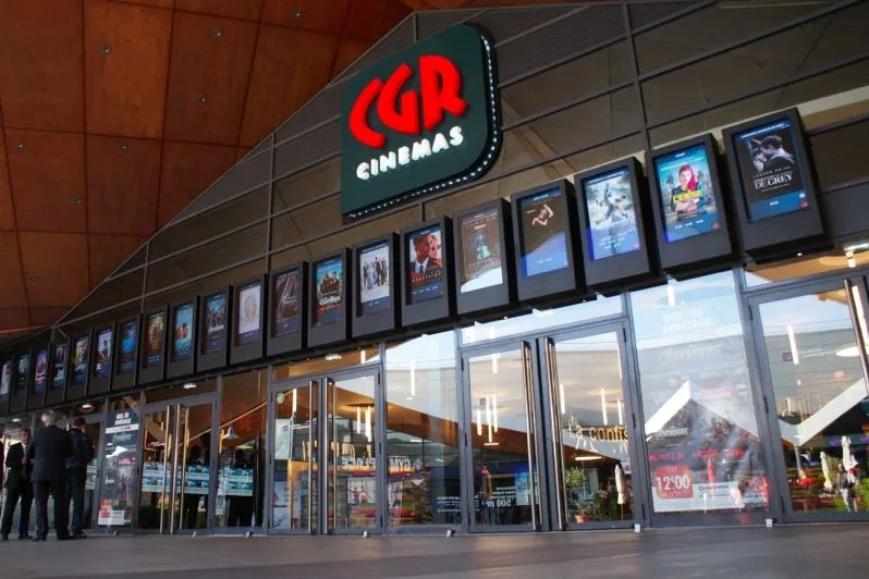 Entrée d’un cinéma avec une rangée d’affiches de films numériques