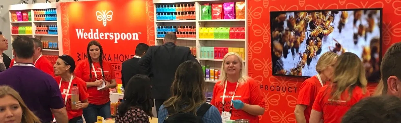 Stand d’exposition avec un grand écran et une équipe en t-shirts orange