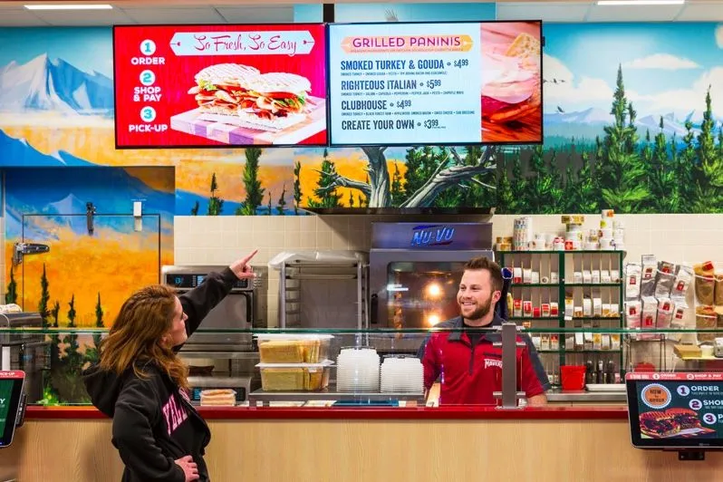 Comptoir de boutique avec des écrans de menu numériques au-dessus