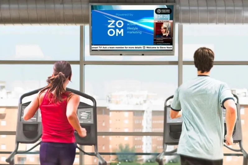 Membres sur des appareils de cardio sous un écran mural