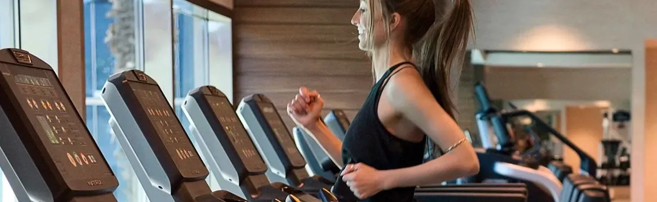 Personnes courant sur des tapis de course dans une salle de sport