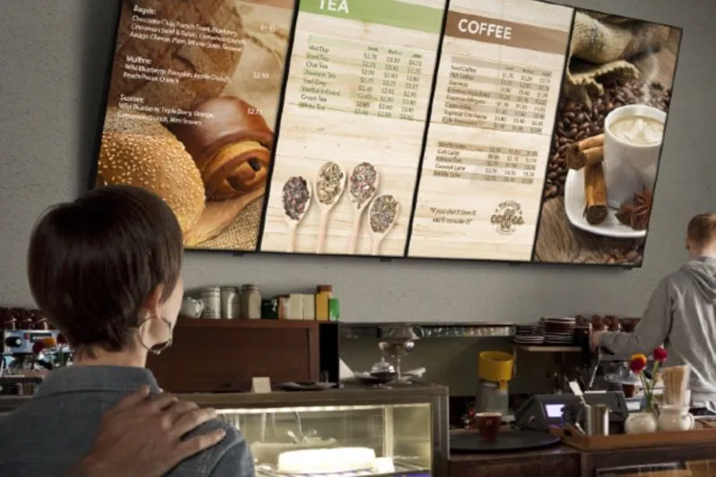 Employé regardant des écrans de menu dans une cantine d’entreprise