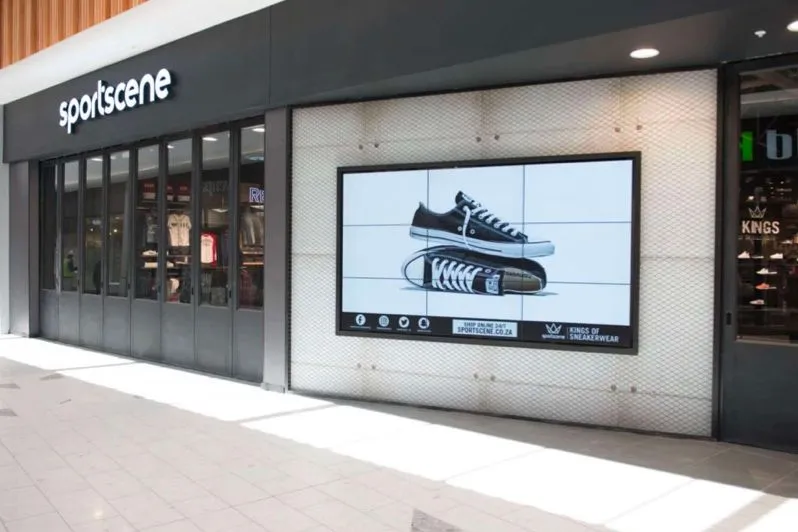 Vitrine avec un mur vidéo présentant des baskets