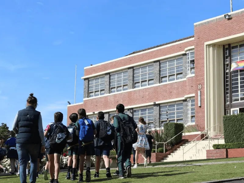 Élèves marchant vers un bâtiment scolaire