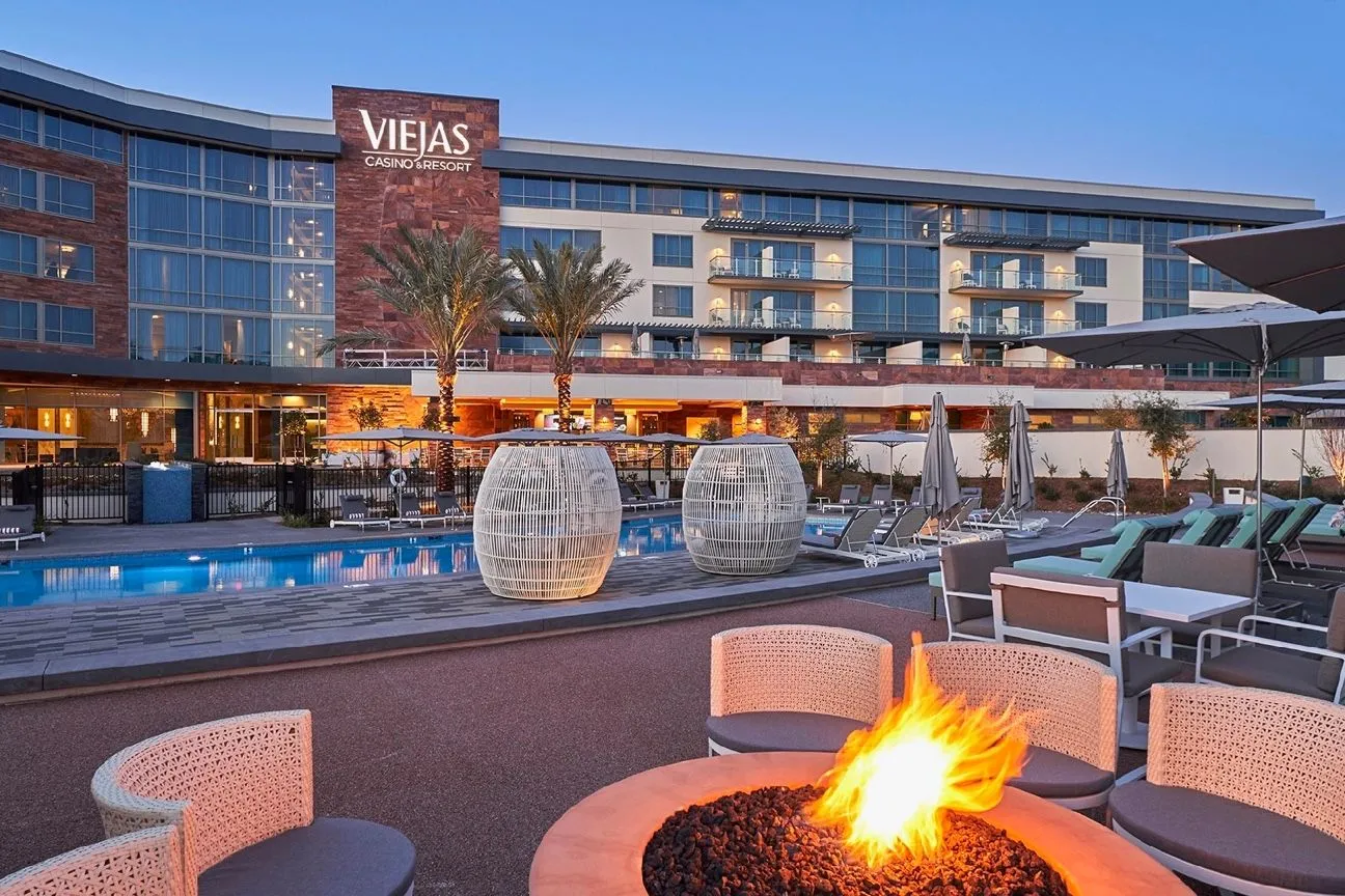 Le Viejas Casino & Resort vu de la piscine, avec un brasero et l’éclairage du soir